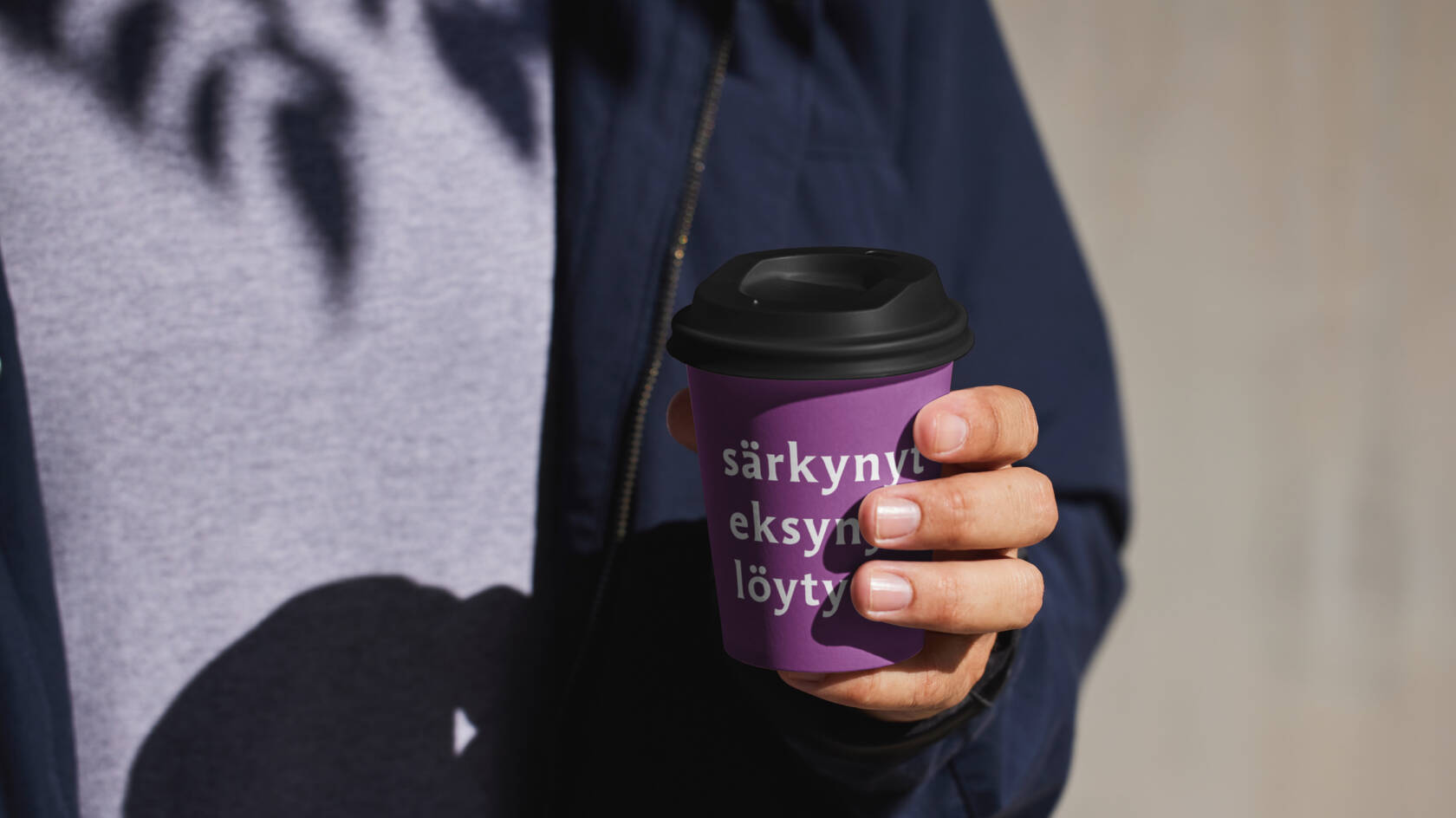 Pahvinen kahvimuki ihmisen kädessä