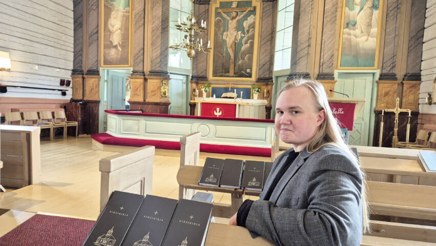 Miika Väänänen istuu Ylikiimingin kirkon penkissä taustallaan kirkon alttari.