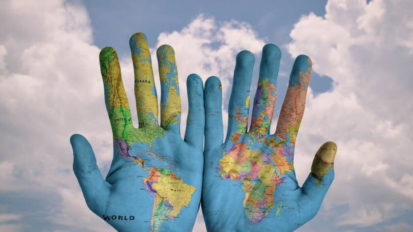 Kuvassa on avoimet kädet ja käsiin on heijastettu maailman kartta. There are open hands on the picture. A world map has been projected on the hands.