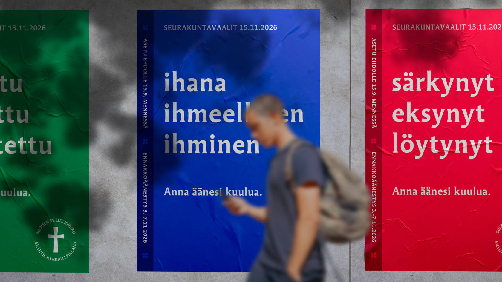 Nuori kävelee kadulla vaalijulisteiden ohi