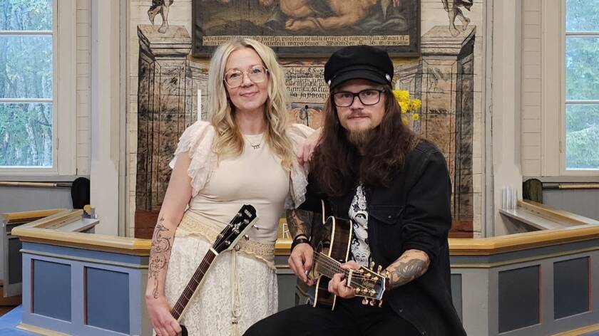 Kuvassa duo Juho ja Pia-Mari alttarin edessä, Pia-Marilla kitara kädessä